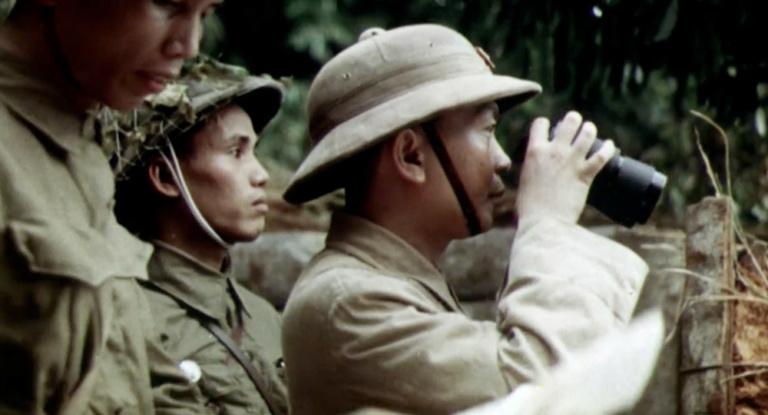 A Viet Minh soldier looks through binoculars.