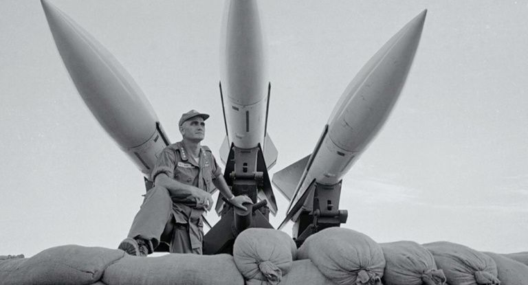 General William Westmoreland stands beneath missiles.