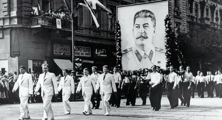 Men in a Soviet parade carry a large image of Joseph Stalin.